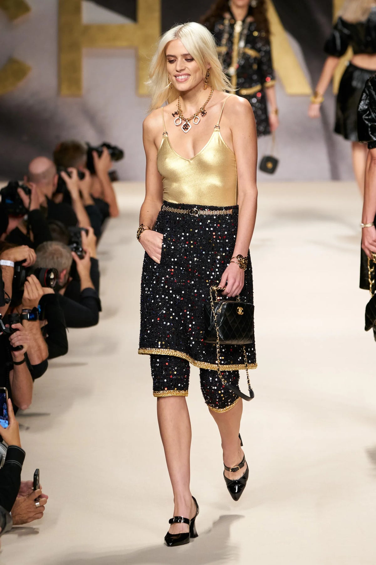 Chanel 2022 CC gold swimsuit, stylish swimwear with gold accents, displayed on model in a fashion photoshoot.
