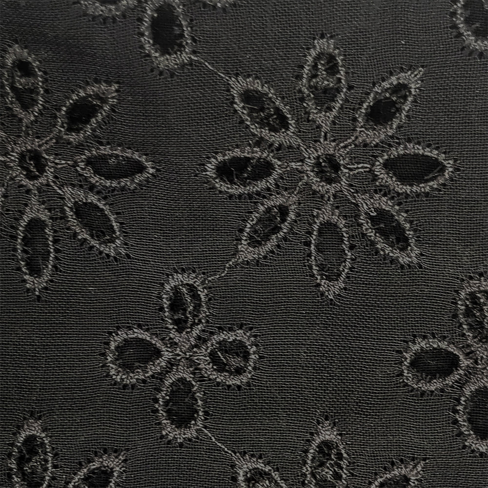 Black sheer broderie blouse by Alaïa, featuring intricate embroidery and lightweight fabric, styled as a fashionable women's top.