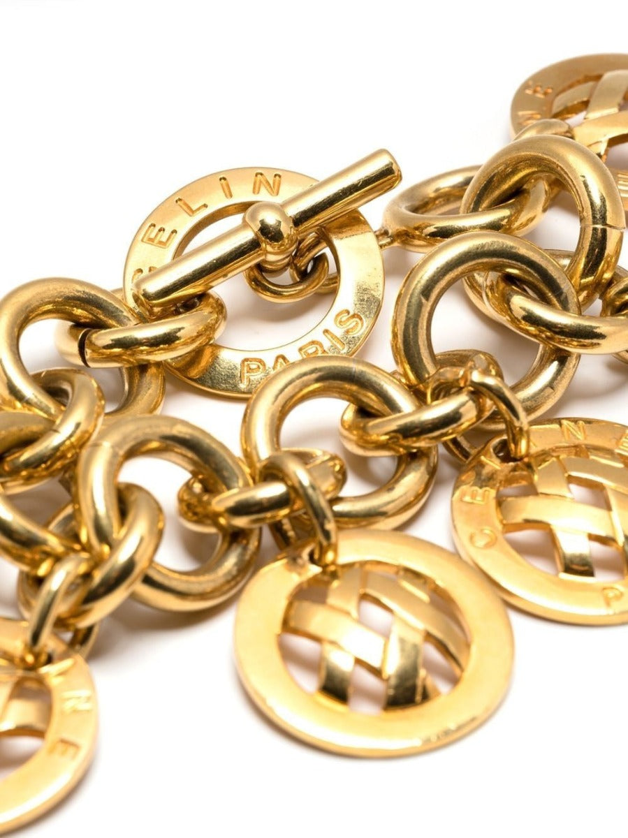 Celine curb chain charm bracelet featuring a sleek gold-tone design with small decorative charms on a white background.