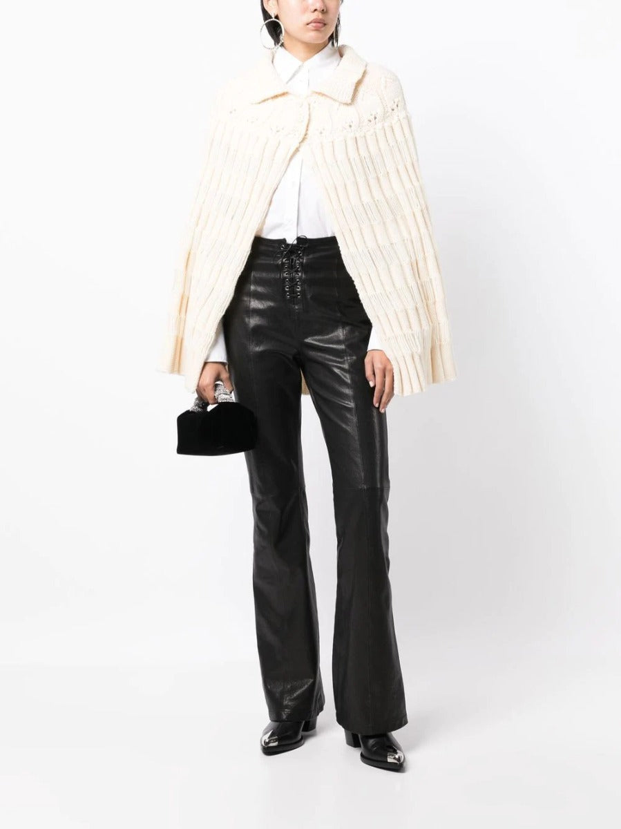 Saint Laurent chunky knit crochet poncho draped over a blazer, showcasing cozy, textured knit fabric and stylish layering.