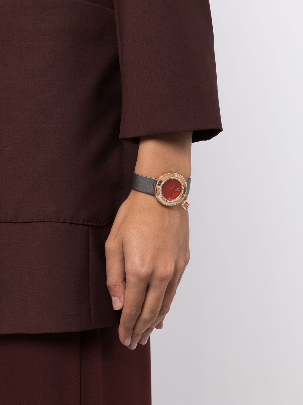 Van Cleef & Arpels rose gold charms watch with a delicate bracelet and elegant watch face featuring floral design.