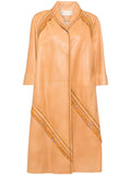 Prada leather camel coat hanging on a rack, showcasing its smooth texture and classic design.