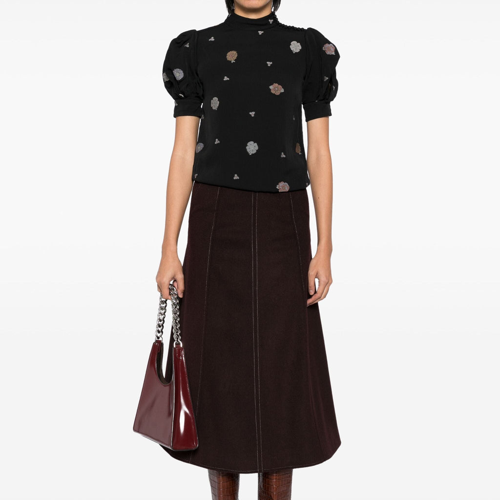 Black embroidered high-neck top by Chloé, featuring intricate embroidery and a sleek high-neck design, shown on a fashion model.