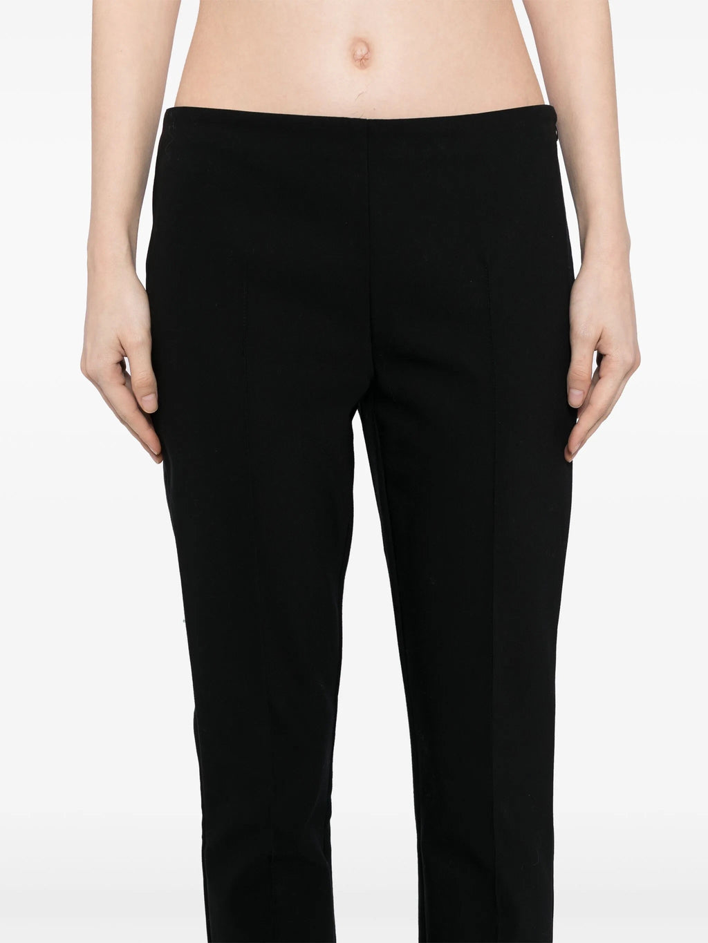 Tapered textured black trousers by The Row, showing fabric detail and tailored fit on a neutral background.
