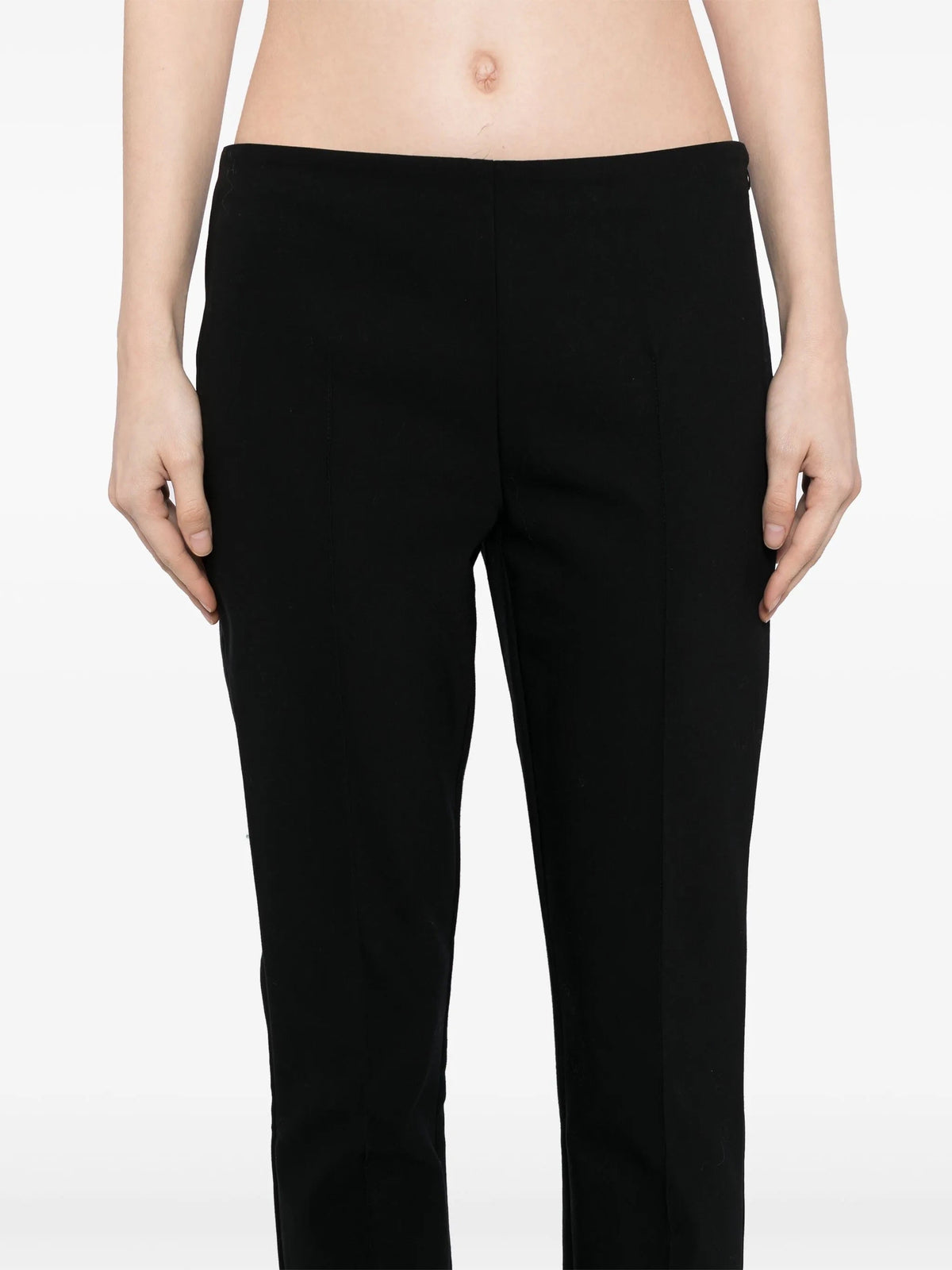 Black tapered trousers by The Row, featuring a sleek fit and smooth fabric, shown laid flat with detailed waist and leg view.