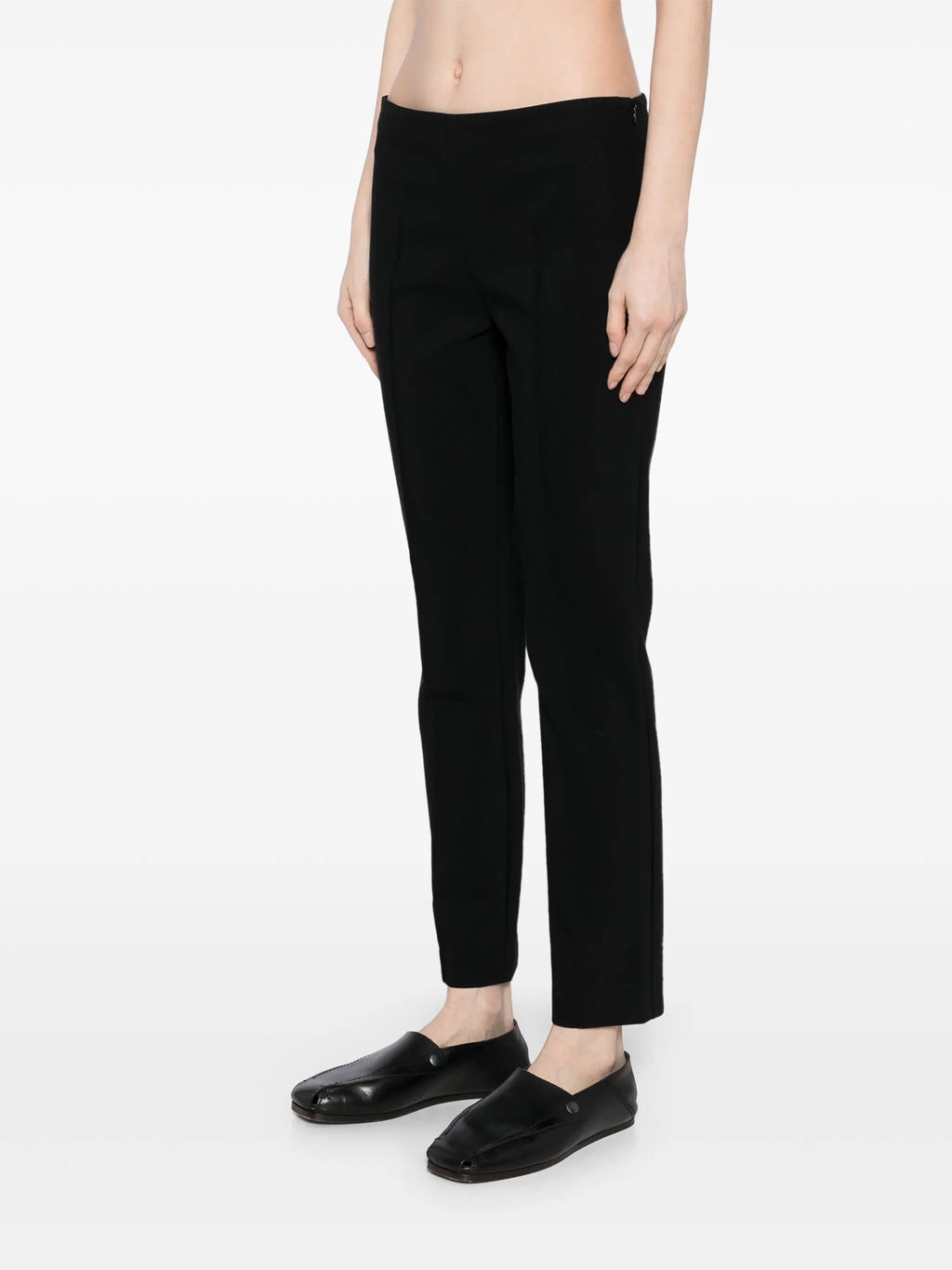 Black tapered textured trousers by The Row, shown with a close-up of the fabric's detailed weave and tailored fit.