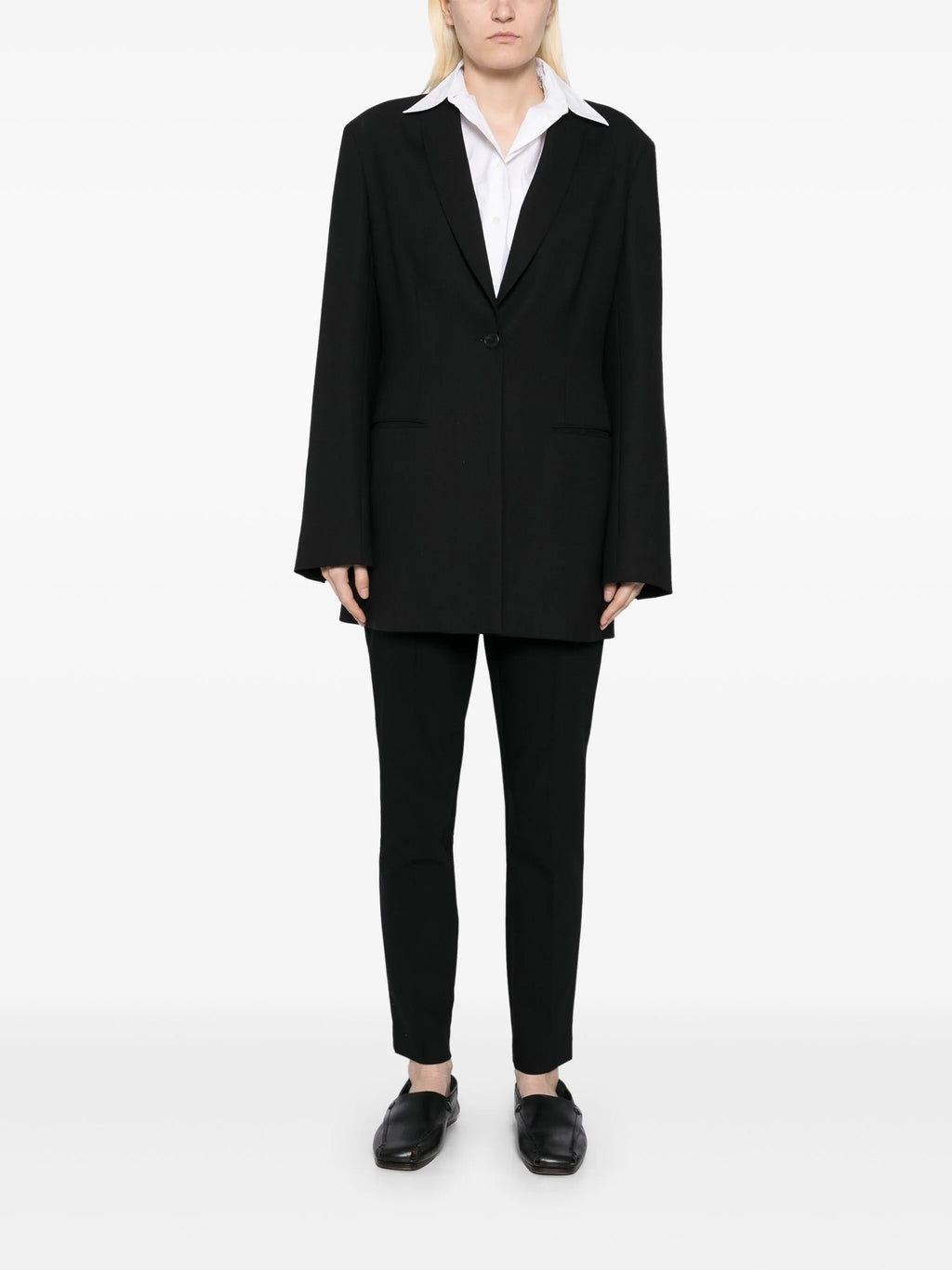 Black tapered textured trousers by The Row, featuring a modern fit and detailed fabric, shown on a neutral background.