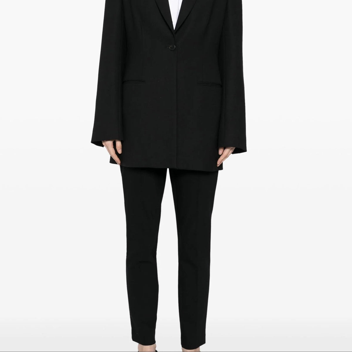 Black tapered trousers from The Row, featuring a sleek fit and smooth fabric, displayed on a neutral background.