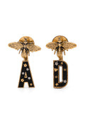 Dior "A" and "D" Bee earrings featuring gold-tone metals and intricate bee motifs on a white background.