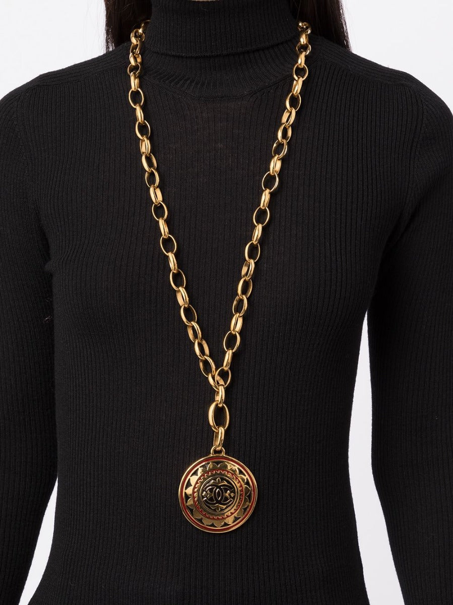 Chanel 1989 CC medallion necklace featuring a gold-tone chain and iconic logo pendant, close-up view of the jewelry piece.