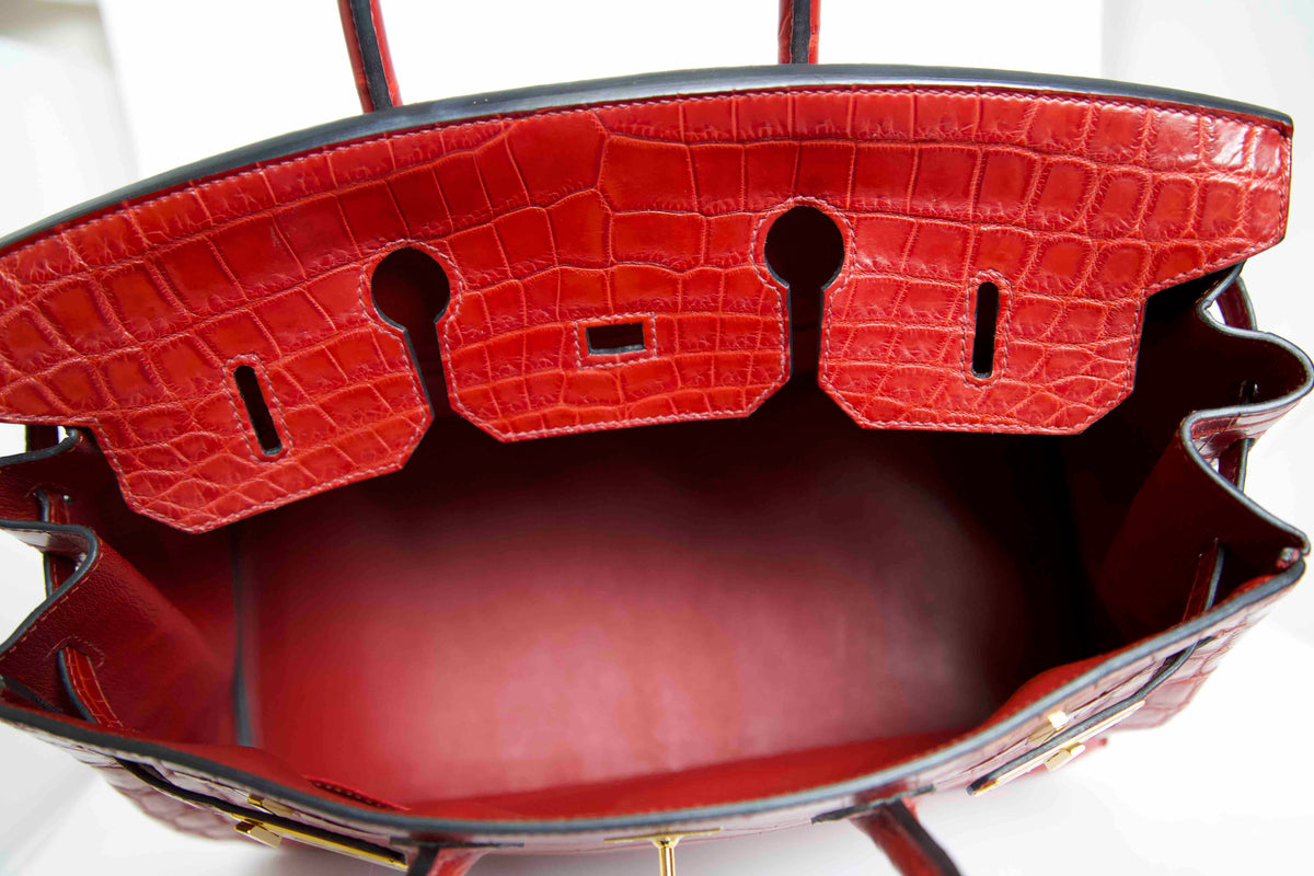 Hermès Birkin 35 Red GHW top handle bag with interior view showing luxurious leather and gold hardware details.