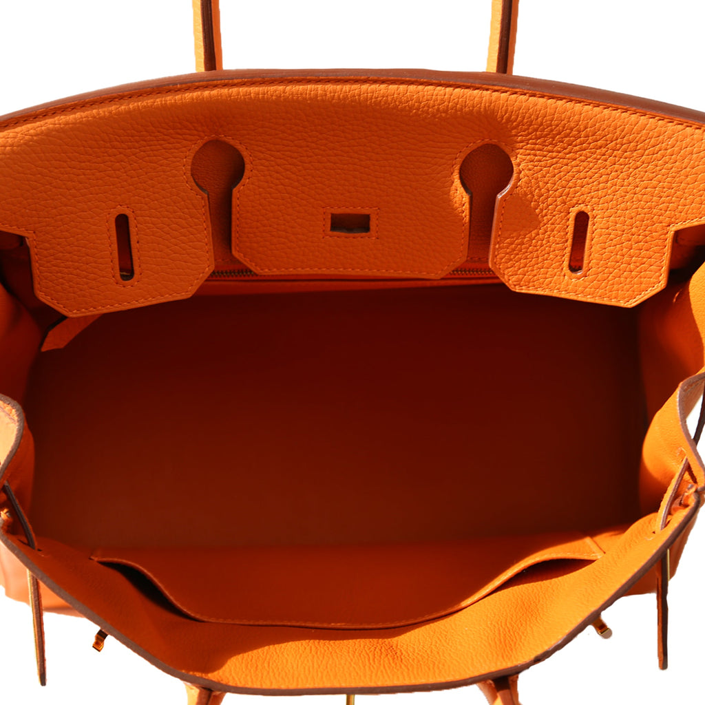 Hermès Birkin 30 Orange Clemence GHW top handle bag with open top, showing interior and luxurious leather details.