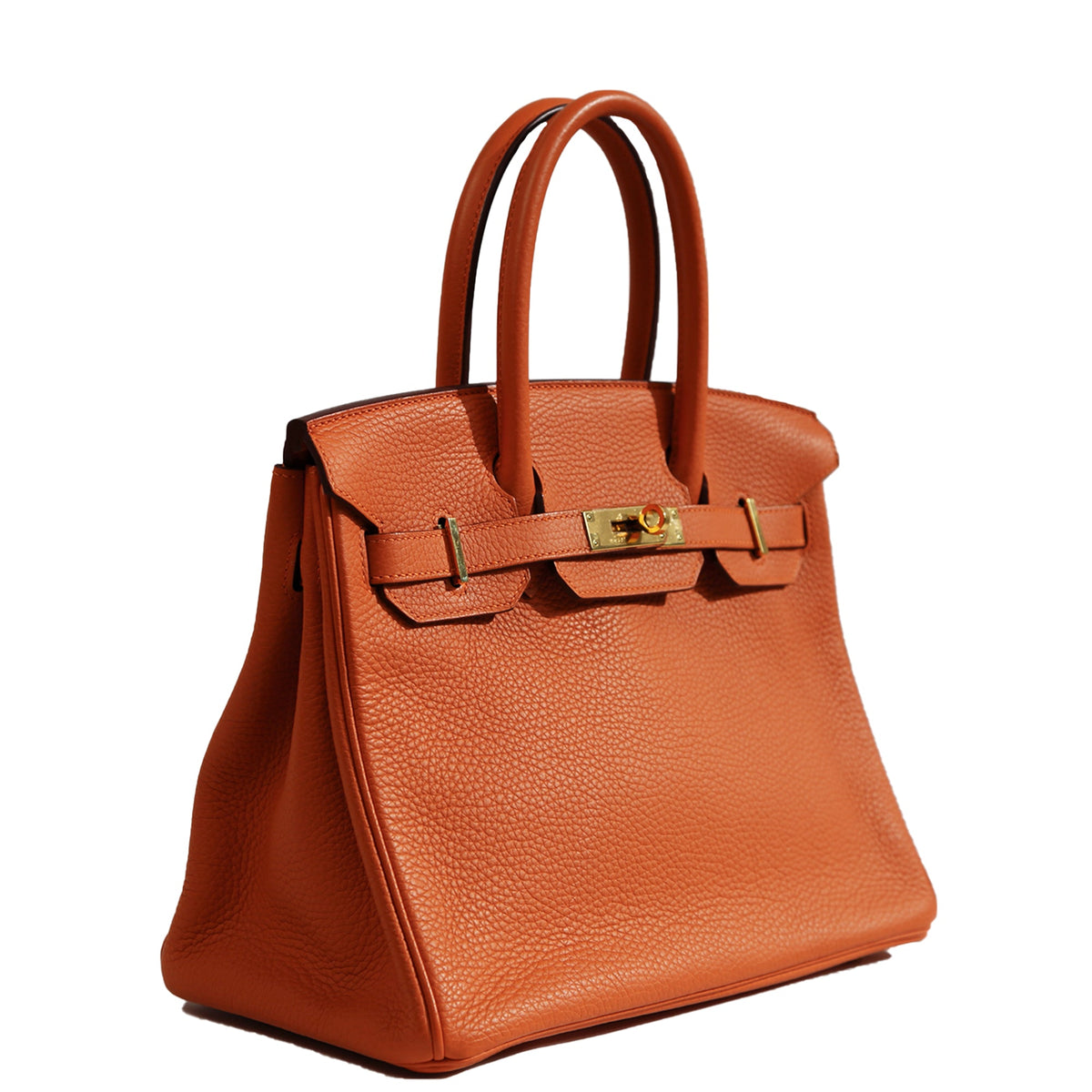 Hermès Birkin 30 Orange Clemence GHW top handle bag shown from a side angle, featuring gold hardware and structured design.