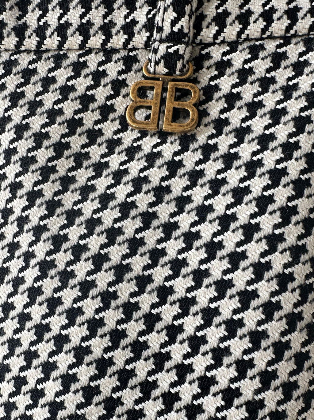Close-up of Balenciaga Houndstooth asymmetrical skirt showing detailed pattern and unique design elements.