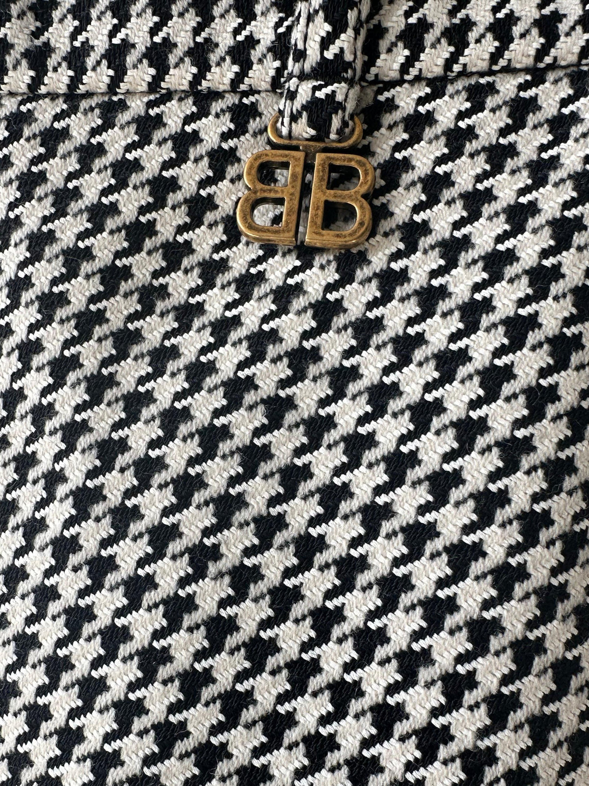 Close-up of Balenciaga Houndstooth asymmetrical skirt showing detailed pattern and unique design elements.
