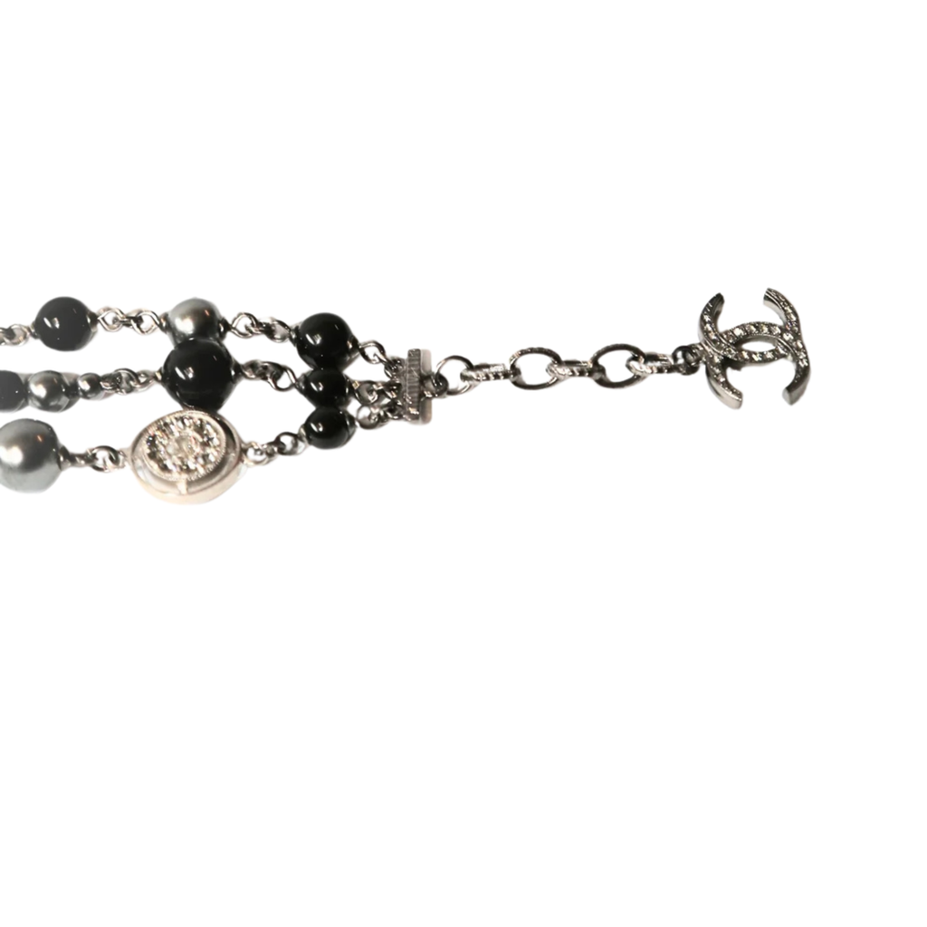 Chanel CC charm beaded bracelet with gold-tone beads and signature logo charm on a delicate chain.