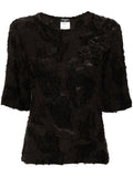 Chanel black cotton top with three decorative brooches, stylish and elegant fashion piece for women.