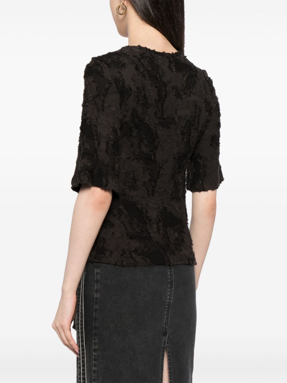 Black Chanel cotton top adorned with three decorative brooches, featuring a stylish and elegant design.