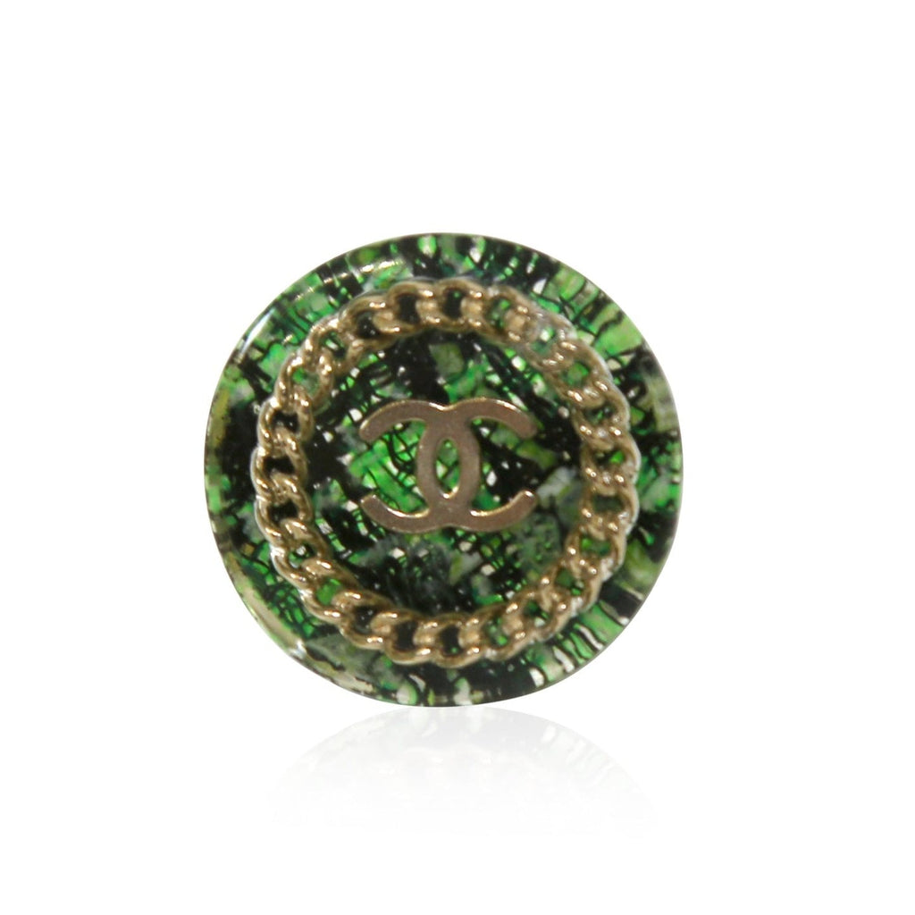 Green tweed Chanel ring featuring a stylish design, showcasing the textured fabric and elegant craftsmanship.