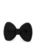 Chanel satin bow brooch featuring a sleek, elegant design with a shiny satin finish and classic bow shape.