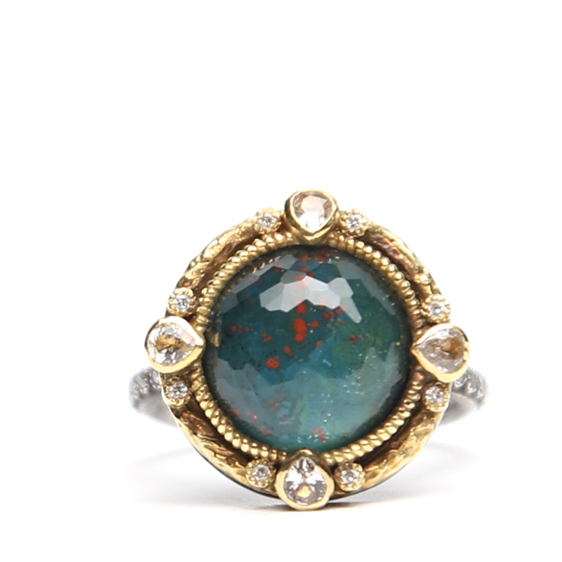 Close-up of green oval stone and diamond ring by Other Designers, showcasing the elegant gemstone and detailed band design.