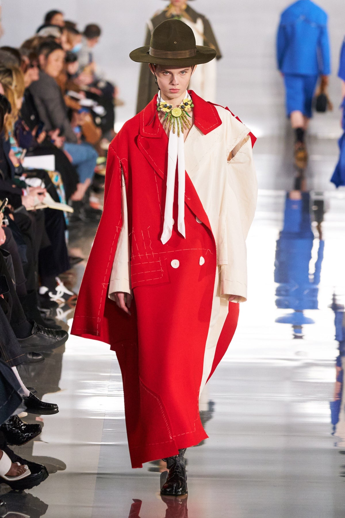 Maison Margiela deconstructed coat showing layered fabric panels and oversized design on a neutral background.