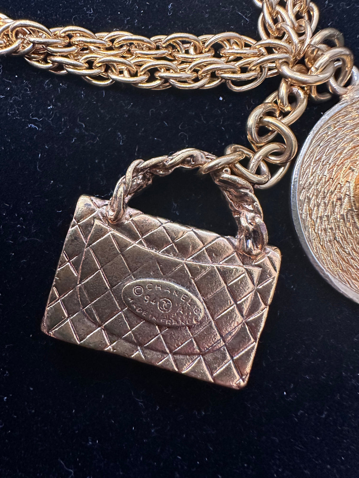 Chanel chain-link necklace with bag charm, featuring metallic links and elegant design, worn as a stylish fashion accessory.