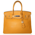 Hermès Birkin 35 Moutarde top handle bag in mustard leather, showcasing its elegant design and structured silhouette.
