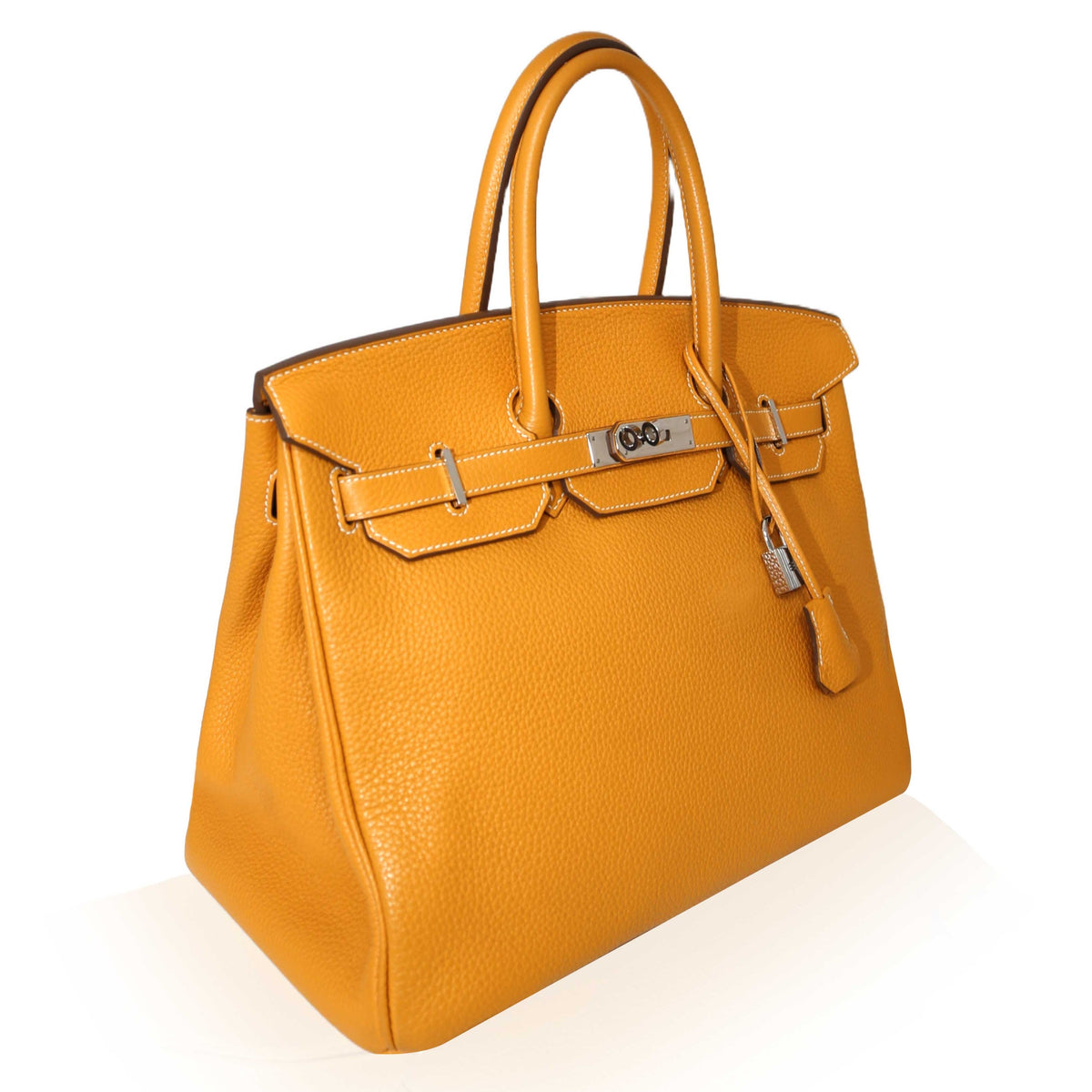 Hermès Birkin 35 Moutarde top handle bag with gold hardware and structured design, featuring tan leather and sturdy handles.