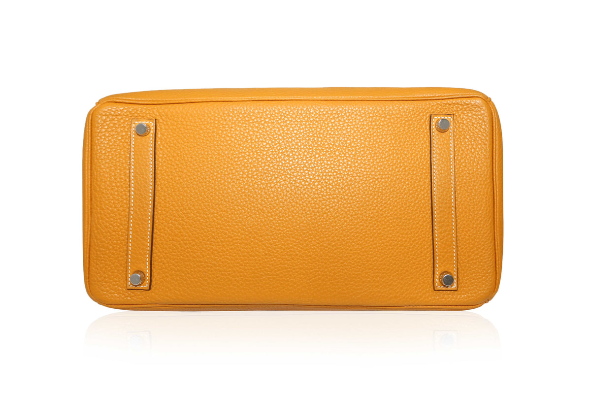 Hermès Birkin 35 Moutarde top handle bag in mustard leather, showing its structured design and elegant gold hardware.