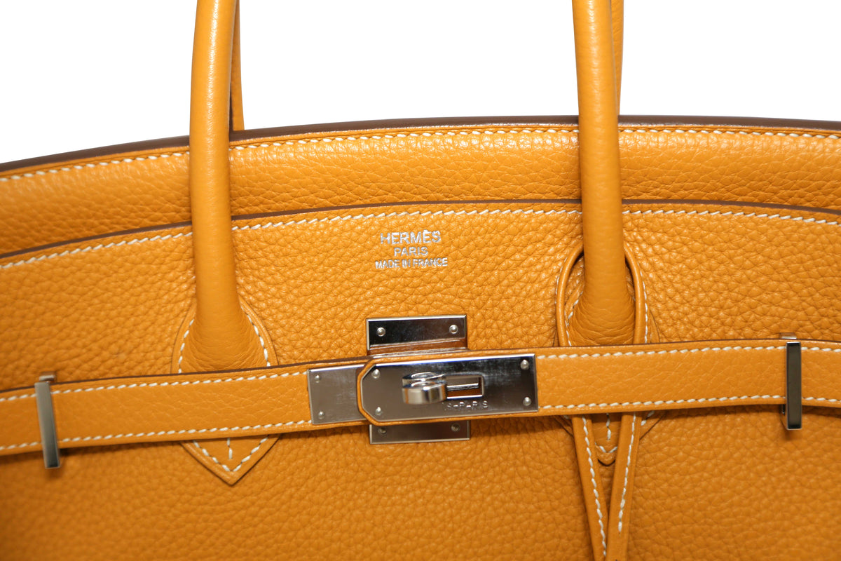 Hermès Birkin 35 Moutarde top handle bag with gold hardware and structured design, showcasing its luxurious mustard leather.