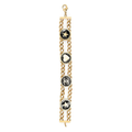 Chanel double chain charm bracelet with interlinked gold and silver chains and decorative charms on a neutral background.