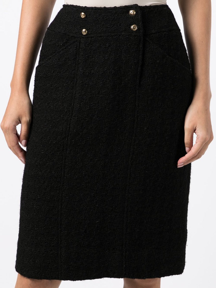 Chanel tweed pencil skirt with tailored fit and classic pattern, close-up of detailed fabric and elegant design.
