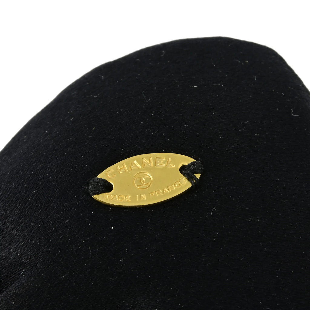 Chanel satin bow brooch featuring a elegant, smooth satin fabric tied into a classic bow design, ideal for accessorizing clothing.