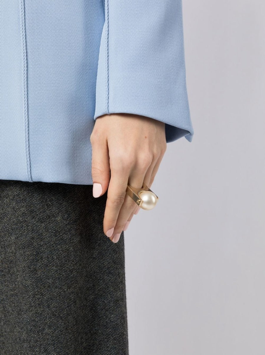 Chanel CC pearl-embellished ring featuring a silver band and elegant pearl accents, showcasing luxury jewelry design.