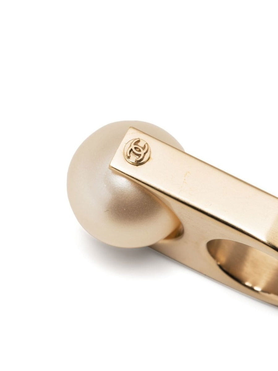 Chanel CC pearl-embellished ring featuring a silver band with elegant pearl accents and signature logo design.