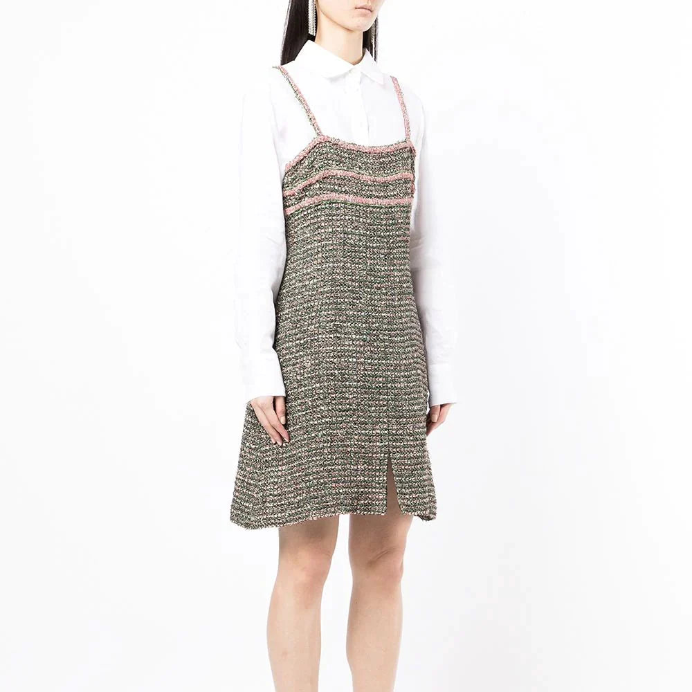 Chanel green tweed dress displayed on a hanger, showcasing its textured fabric and classic tailored style.