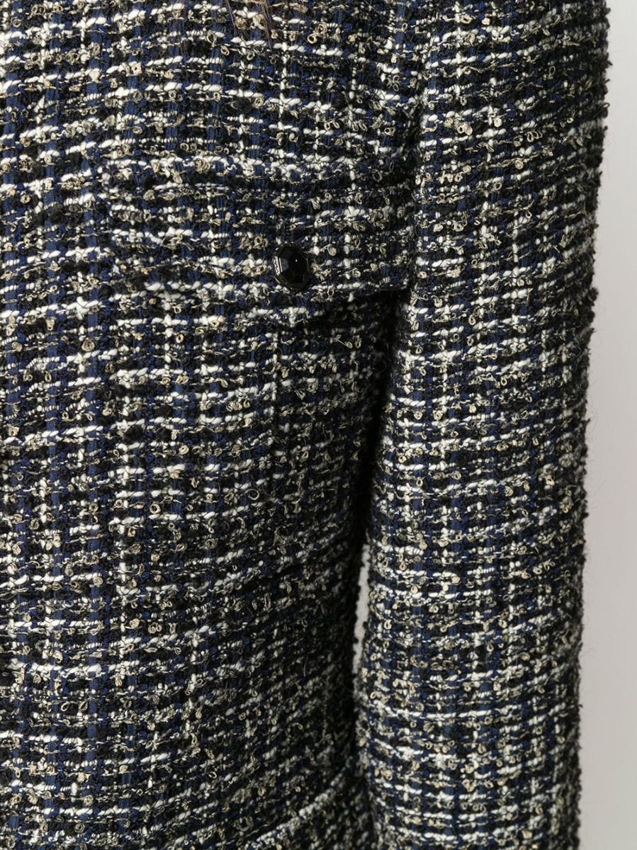 Navy Chanel bouclé tweed jacket with classic tailored fit, featuring textured fabric and elegant design, perfect for sophisticated style.