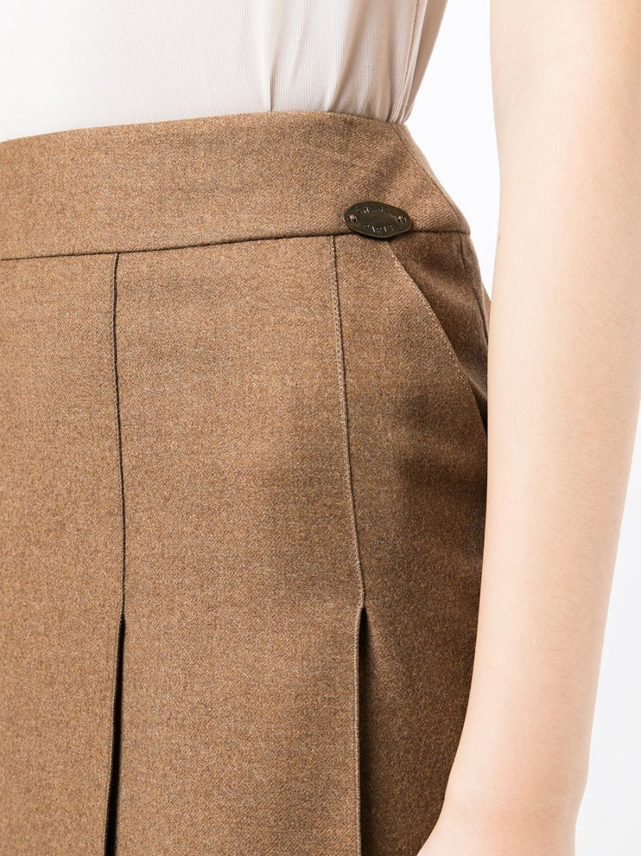 Chanel pleated brown skirt with a high waist and flowing fabric, shown on a model against a neutral background.