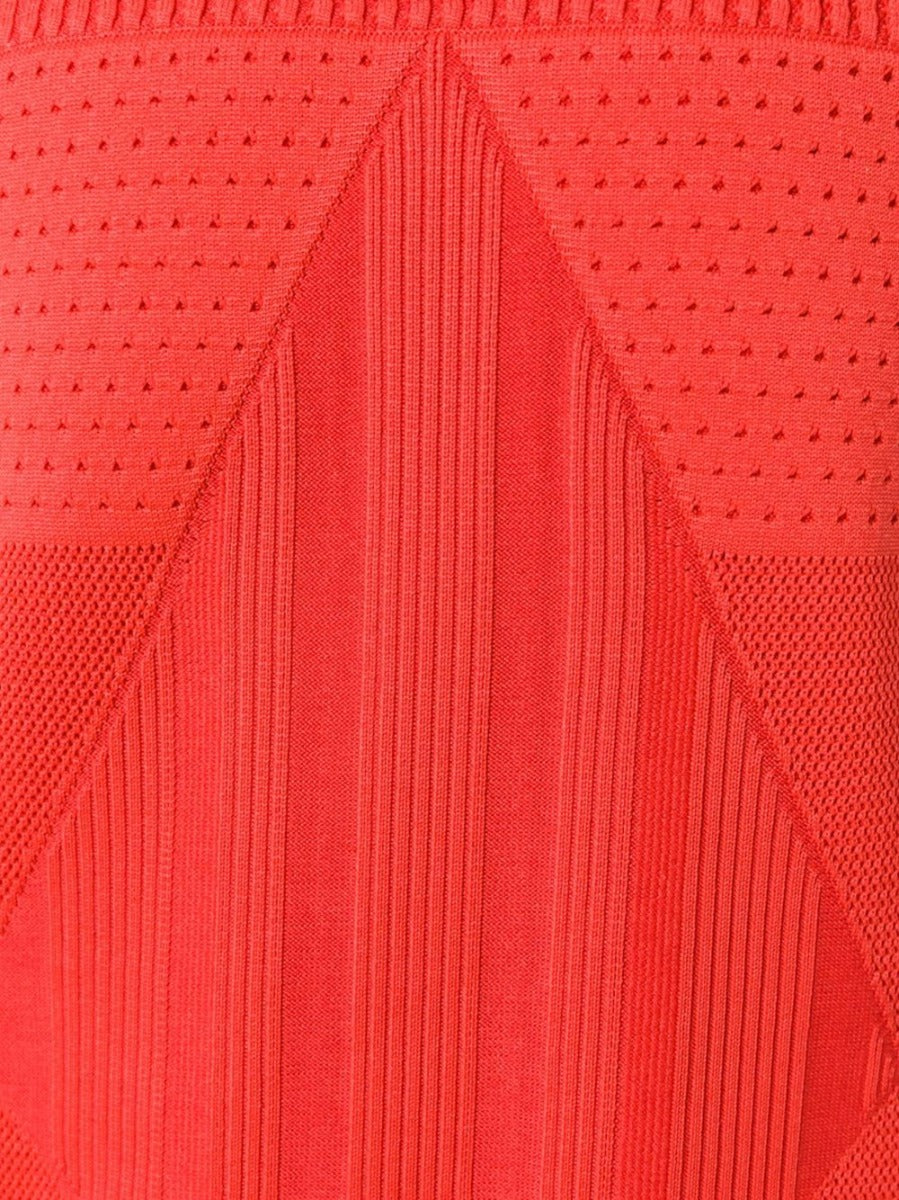 Chanel sleeveless red knit dress hanging on a white background, showcasing its fitted design and vibrant color.