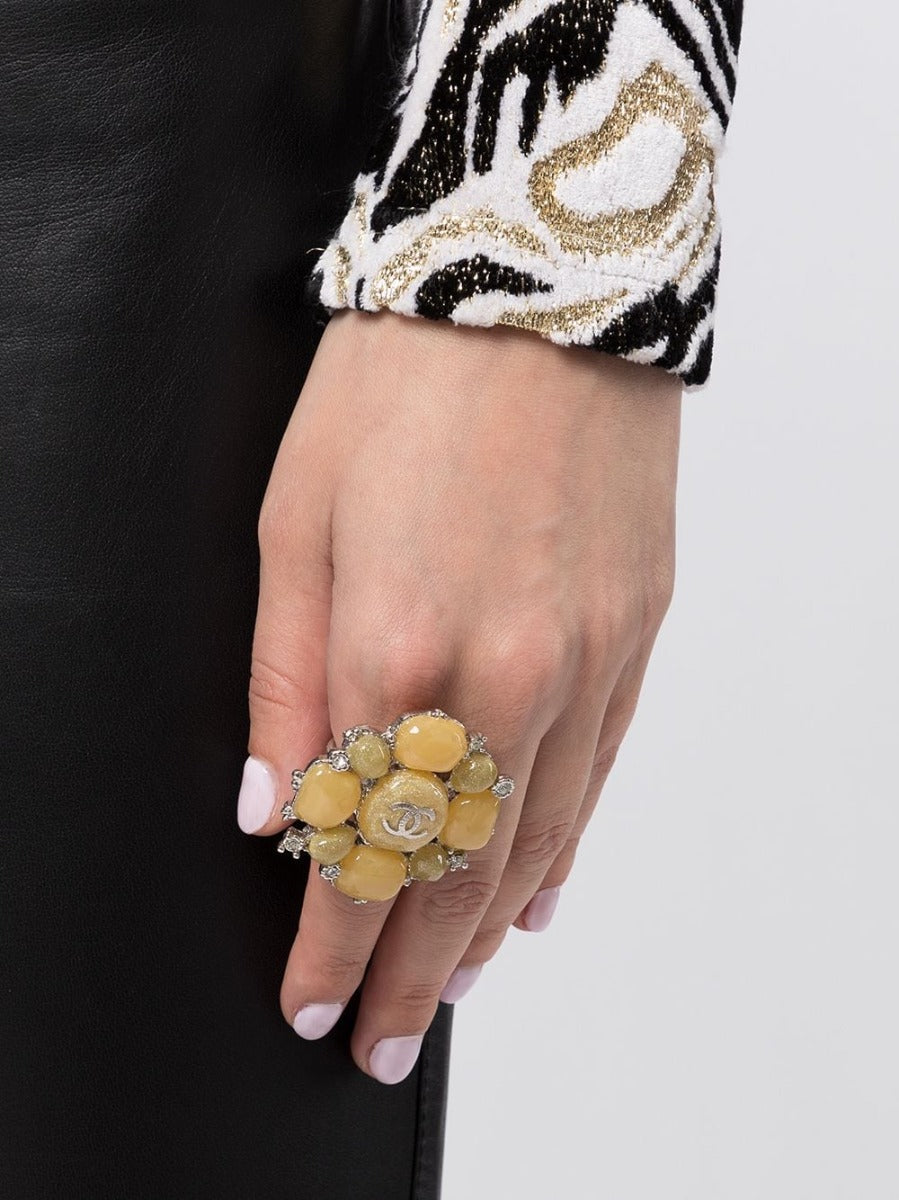 Chanel yellow stone embellished ring showing a gold band with vibrant yellow stone and decorative accents.
