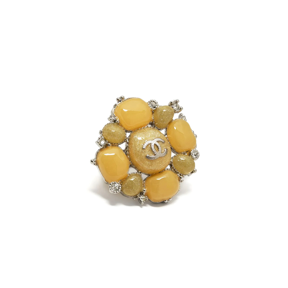 Yellow stone embellished Chanel ring with sparkling accents, showcasing a stylish jewelry piece on a sleek ring design.