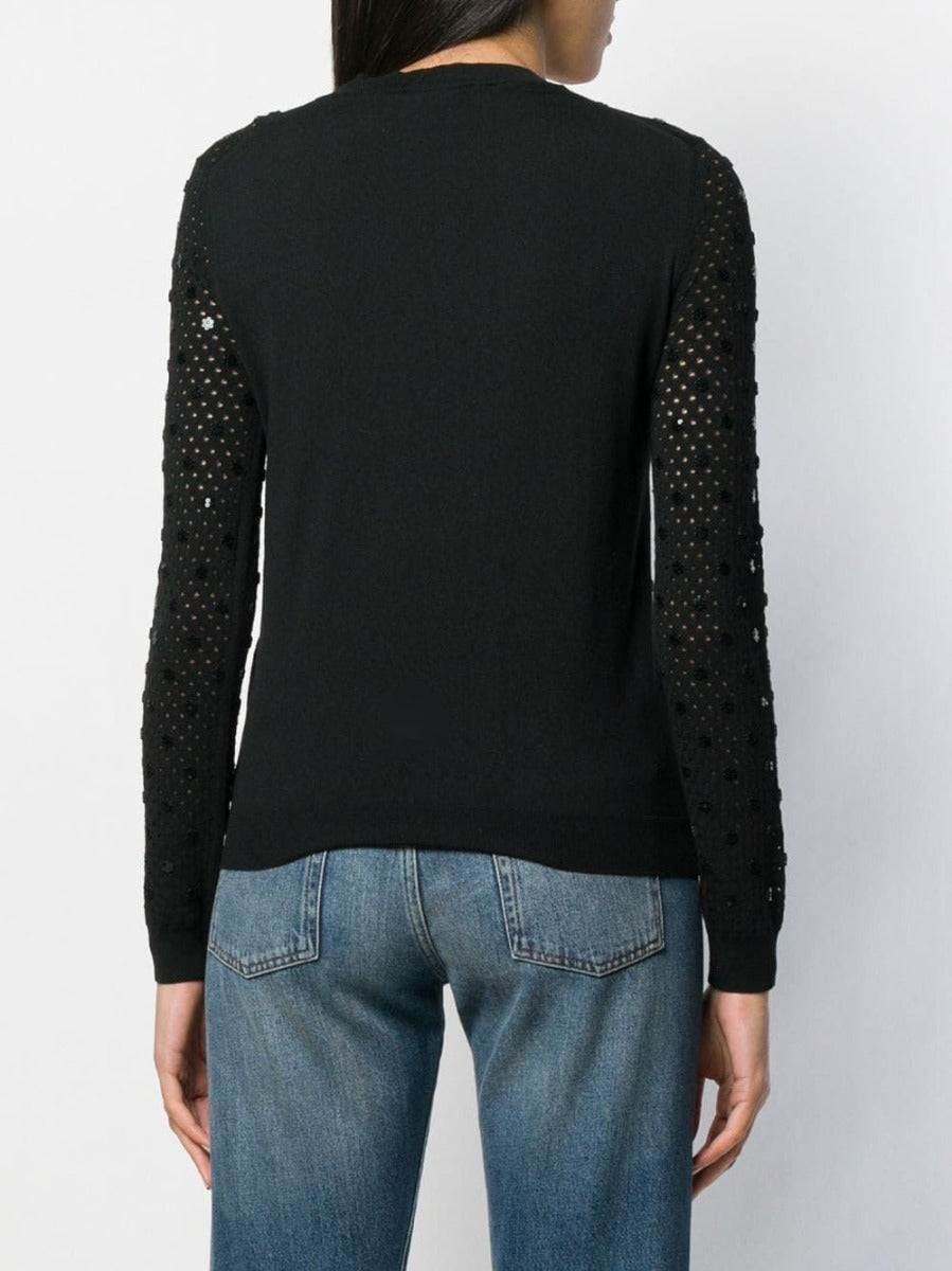 Louis Vuitton black sequin embellished top with shimmering details and long sleeves, stylishly displayed on a hanger.